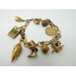 A 9ct gold charm bracelet with 9 charms including a two Victorian charms,
