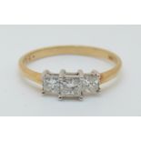 An 18ct gold ring set with three princess cut diamonds, total 0.