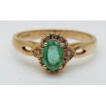 A 9ct gold ring set with an oval emerald surrounded by diamonds (size O)
