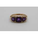 A 9ct gold ring set with three amethysts and four diamonds, 3.