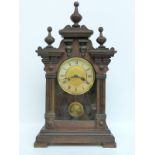 A late 19thC / early 20thC oak cased mantel clock with reeded and finial decoration the brass dial