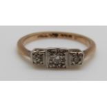 A 9ct gold ring set with three diamonds in a palladium setting, 1.