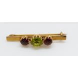 A 15ct gold brooch set with a peridot and two garnets, 3.
