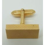 A gold cufflink with engine turned design (9.