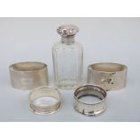 A pair of oval hallmarked silver engine turned napkin rings and two further napkin rings,