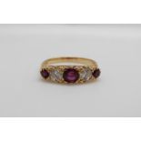 An 18ct gold ring set with three rubies the largest approximately 0.