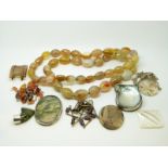 A yellow metal and amber necklace, agate beaded necklace, a necklace set with garnet beads,