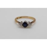 An 18ct gold ring set with a sapphire and two diamonds in a platinum setting (size O)