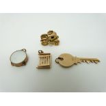 Four 9ct gold charms, key, drum, gate and a coronation coach, 7.