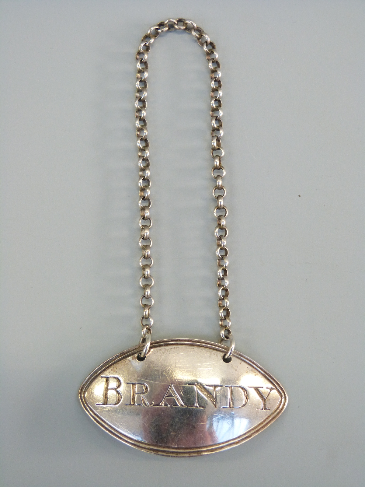 A Georgian hallmarked silver bottle ticket for Brandy,