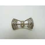 An 18ct gold brooch in the form of a bow set with rose cut diamonds and three pearls to the centre,