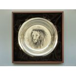 A white metal shallow plate decorated with a lion by Bernard Buffet,