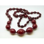 A cherry amber necklace of 46 graduated ovoid beads, the largest approximately 22x20mm, 80g,