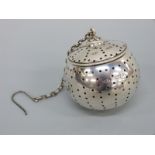 An Edward VII hallmarked silver 'drop in' tea strainer with hinged lid and suspension chain,