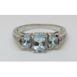 A 10K white gold ring set with blue topaz and diamonds to the shoulders (size N)