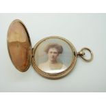 A Victorian yellow metal locket with painted portrait within, 18.