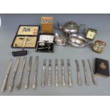 A collection of silver plated cutlery, plated tea ware, travelling clocks,