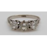 A platinum ring set with three round brilliant cut diamonds with further diamonds to the shoulders,