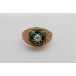 A 9ct gold ring set with a seed pearl surrounded by turquoise cabochons (size M)
