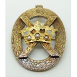 A Victorian pendant/brooch with engraved foliate decoration featuring a cross and a crown set with