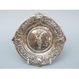 A Victorian hallmarked silver embossed dish depicting a cherub playing a violin,