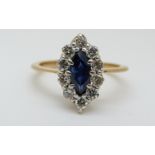 An yellow metal ring set with a marquise cut sapphire surrounded by diamonds (size L)