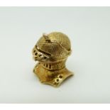 A 9ct gold charm in the form of a knight's helmet,