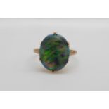 A Victorian 15ct gold ring set with a black opal cabochon, 1.5cm x 1.