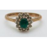 A 9ct gold ring set with an apple green oval emerald surrounded by diamonds (size K)