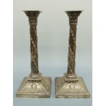 A pair of Edward VII hallmarked silver Corinthian column candlesticks with embossed neoclassical