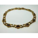 A 19thC Austro-Hungarian necklace set with pearls and garnets in an ornate setting