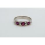 An 18ct white gold ring set with three rubies and diamonds, 4.