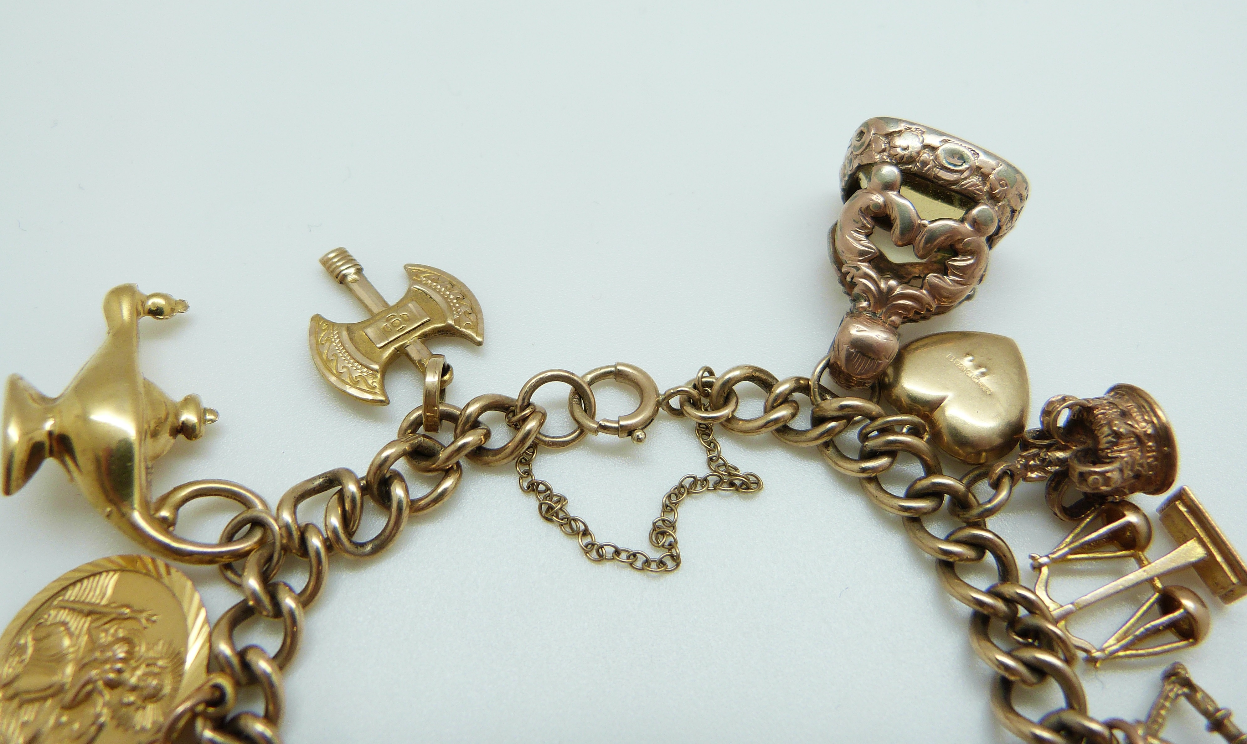 A 9ct gold charm bracelet with eleven 9ct gold charms including a crown, St Christopher, purse, - Image 5 of 8