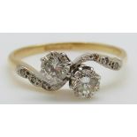 An 18ct gold ring set with two round cut diamonds each measuring approximately 0.