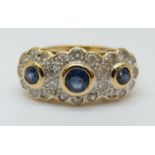 An 18ct gold ring set with three round cut sapphires surrounded by diamonds (size O)