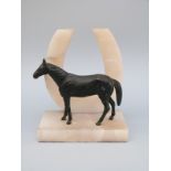 A spelter horse figure on an alabaster horseshoe base, H14.