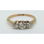 An 18ct gold ring set with three diamonds in a platinum setting, the centre diamond approximately 0.