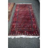 A Baluch rug, with allover geometric octagon design and stylised floral border, 210 x 105cm.