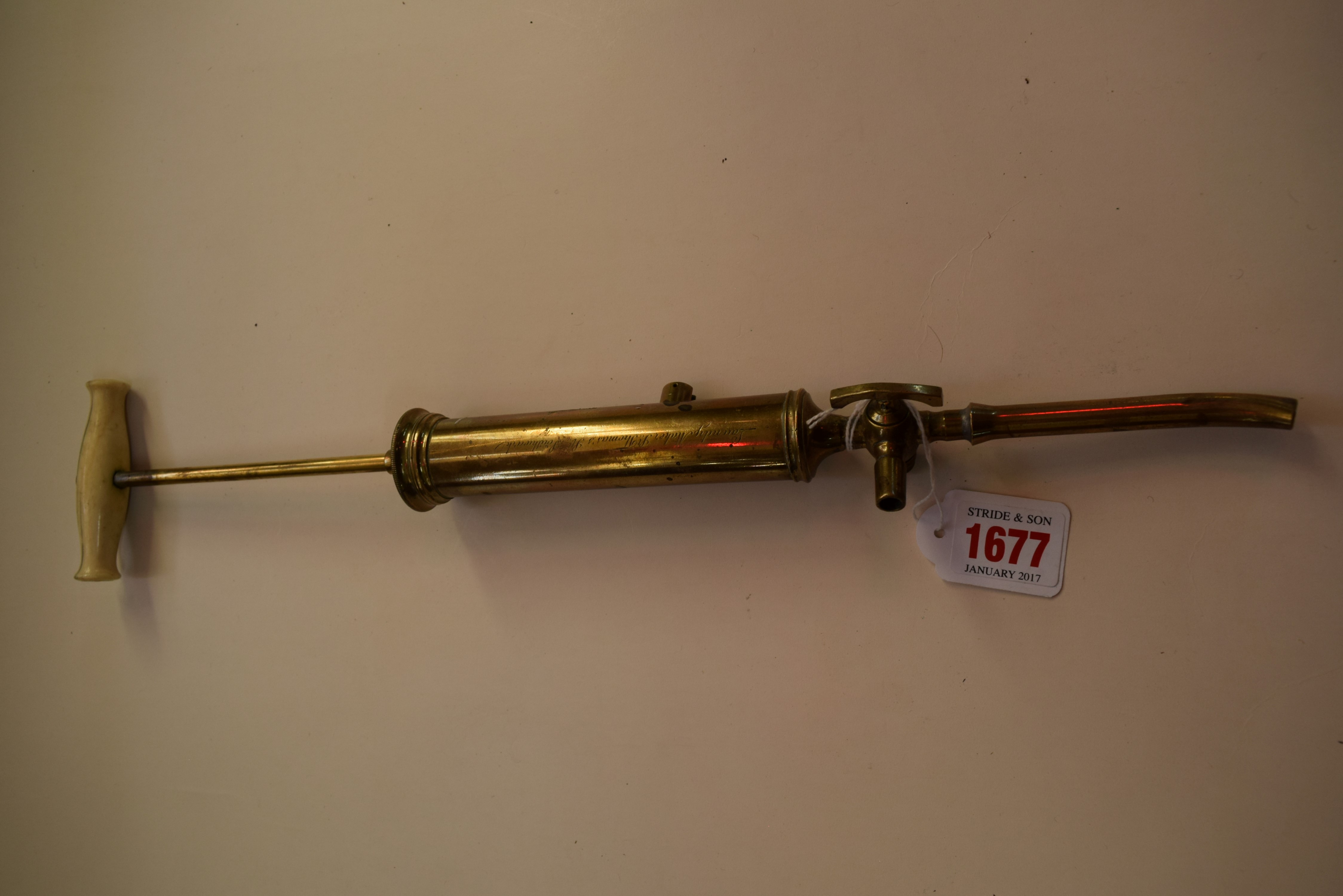 A Georgian brass and ivory handled syringe, inscribed 'Laundry Maker, St Thomas's St, Southwark',
