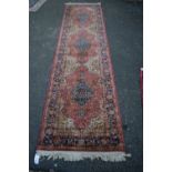 A machine made runner, with triple medallion field, 290 x 72cm.