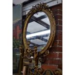 An antique gilt gesso framed oval three branch girandole, 96 x 58.5cm.