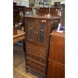 An early 20th century oak and inlaid narrow cabinet, 55cm wide.
