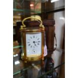 An antique gilt brass oval carriage clock, with bell striking alarm, height including handled 15.