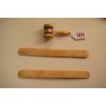 An antique ivory gavel, 8cm long; together with a pair of bone items.