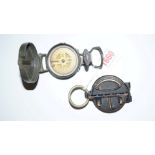 A military style lacquered brass pocket compass; and another similar.