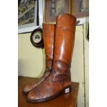 A pair of tan leather riding boots.
