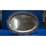 An Indian white metal oval tray, having repouse and hammered decoration to rim, 34.5cm.