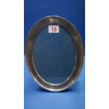 A silver oval photograph frame, by W Comyns, London 1915, having engine turned decoration, 23cm.