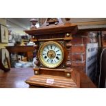 An early 20th century German walnut andcbeech mantel clock, striking on a gong, 44.5cm high.