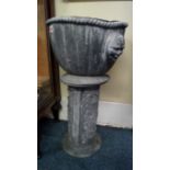 A pair of antique cast lead garden urns on matching stands, 61cm high.